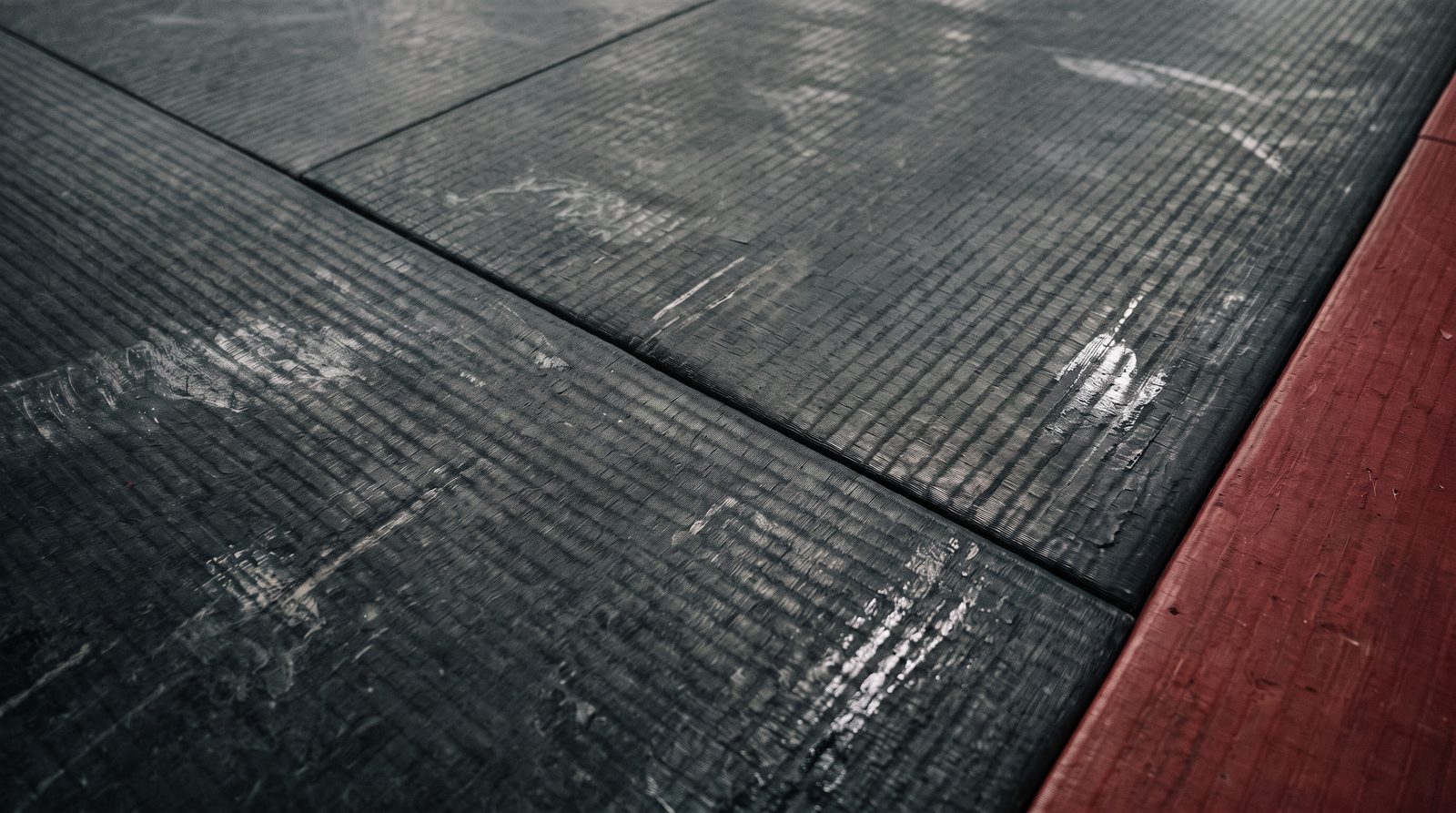 Le même tatami après vapeur : surface noire mate et propre, grain net, joint dégagé, éraflures d’usure toujours visibles